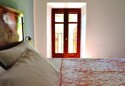 a bedroom with a bed and a door with a window at b&b CASCINA SORTINA Country House in Ozzano Monferrato