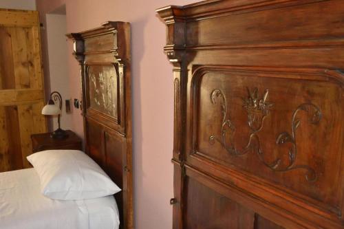 a bedroom with a wooden bed and a wooden headboard at b&b CASCINA SORTINA Country House in Ozzano Monferrato