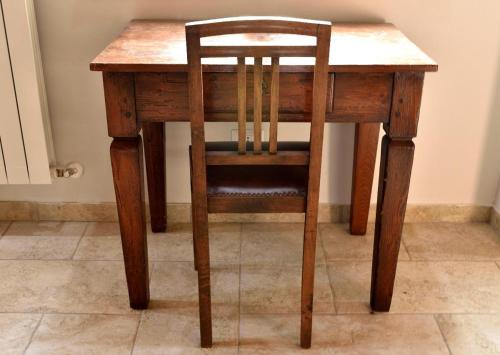 a wooden table and a chair at a table at b&b CASCINA SORTINA Country House in Ozzano Monferrato