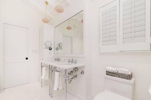 西棕櫚灘的住宿－Maison Papillon Vacation Home，白色的浴室设有水槽和镜子