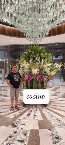 a man standing next to a tree in a building at Two-Bedroom at San Remo Oasis in Cebu City