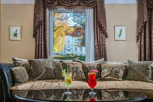 a living room with a couch and a window at La Contessa Castle Hotel in Szilvásvárad