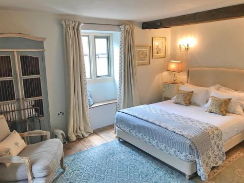 a bedroom with a bed and a chair and a window at Brook House in Nunney