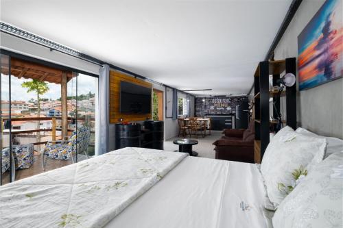 a bedroom with a bed and a living room at Pousada Encantos de Socorro in Socorro