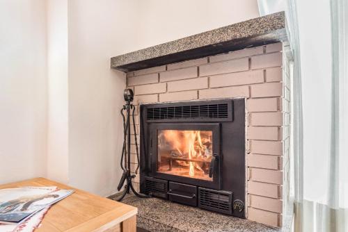 a brick fireplace with a fire in it at Condominio Lucia 7 in Pinzolo