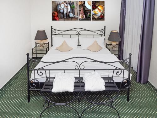 a bedroom with a black bed with two pillows at Hotel Rhyhof in Frauenfeld