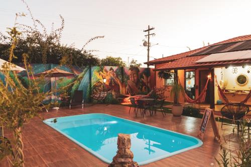 a house with a swimming pool and a mural at Pousada Lua Clara in Alto Paraíso de Goiás