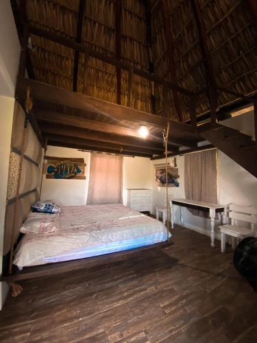 a bedroom with a bed and a table in a room at Hotel Maya Jade in Monterrico