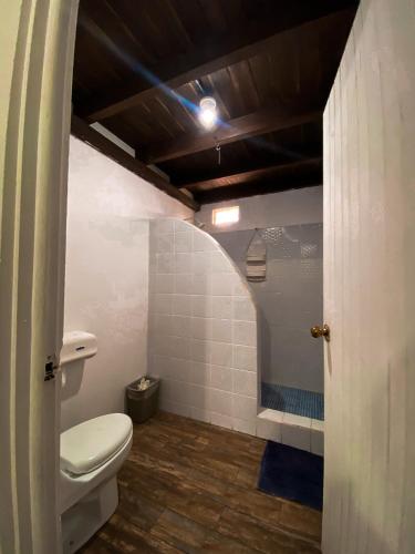 a bathroom with a toilet and a shower at Hotel Maya Jade in Monterrico