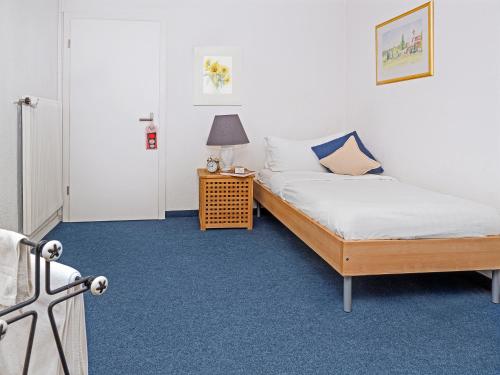 ein Schlafzimmer mit 2 Betten und einer Lampe auf einem Tisch in der Unterkunft Hotel Rhyhof in Frauenfeld
