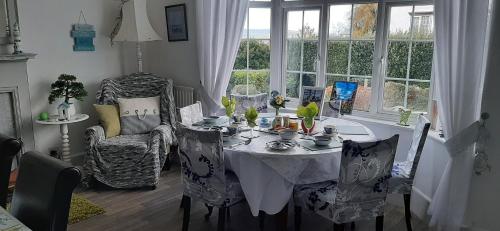 a dining room with a table and chairs and a window at Malindi bed and breakfast in Exmouth