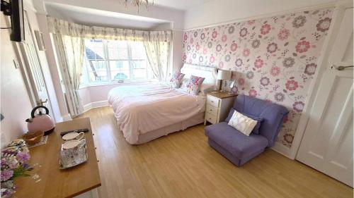 una piccola camera da letto con un letto e una sedia di Malindi bed and breakfast a Exmouth