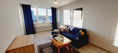 a living room with a blue couch and a table at Central Apartments View in Gdańsk
