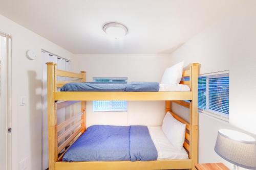 two bunk beds in a small room with a desk at DnA Tiny beach House in Reedsport