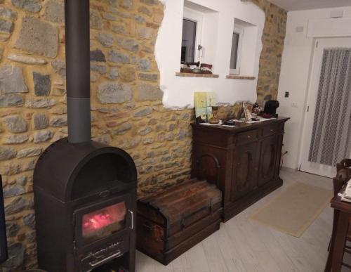 a wood stove in a room with a stone wall at Villa Bersani in CastellʼArquato