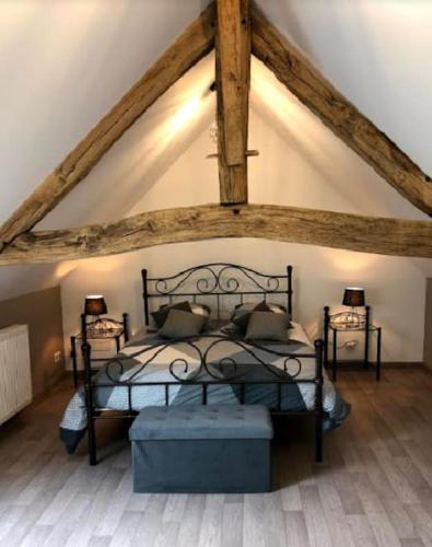 - une chambre avec un lit noir et 2 tables dans l'établissement Gîte la bergerie, piscine chauffée,, à Couzon