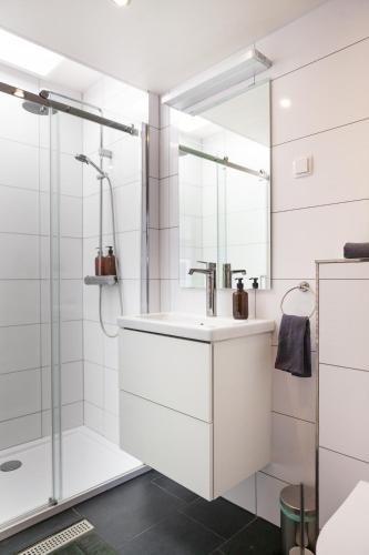 a white bathroom with a sink and a shower at Pait's Laand Bed & Breakfast in Overschild