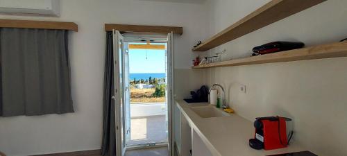 uma cozinha com um lavatório e um balcão com uma janela em Casa Di Kimolos em Kimolos