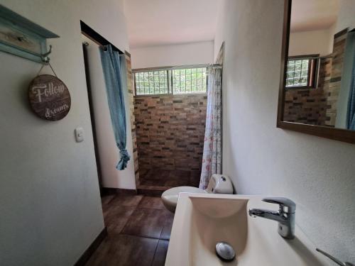 a bathroom with a sink and a toilet and a mirror at Guesthouse Casa Avi Fauna in Ocotal