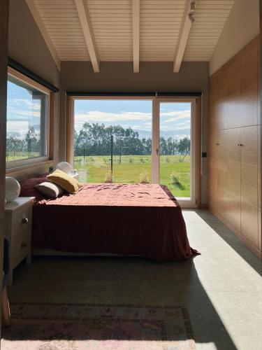 a bedroom with a bed and a large window at La Quintana De José in Muros de Nalón