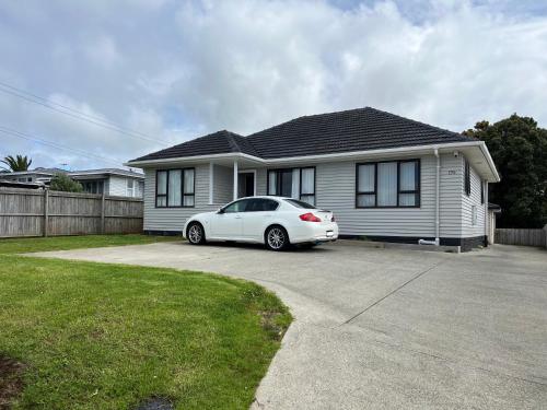 ein weißes Auto, das vor einem Haus parkt in der Unterkunft Yucca Home in Auckland