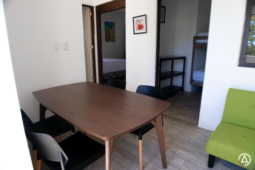 a table and chairs in a room with a bedroom at Hotel Maya Jade in Monterrico
