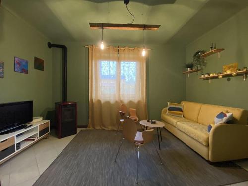 ein Wohnzimmer mit einem Sofa und einem TV in der Unterkunft La casa dei Nonni Guest House in Cuneo