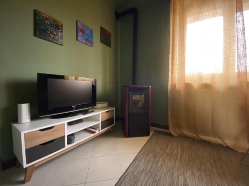 a living room with a flat screen tv and a window at La casa dei Nonni Guest House in Cuneo