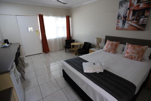 a bedroom with a large white bed in a room at Tropic Coast Motel in Mackay