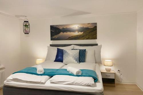 una camera da letto con un grande letto con cuscini blu e bianchi di Grubenmann Appartements Herisau a Herisau