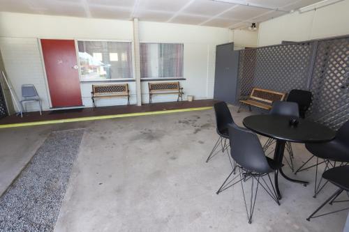 a room with a table and chairs and benches at Tropic Coast Motel in Mackay
