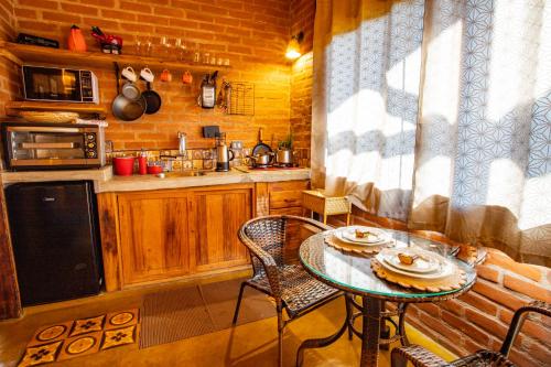 a kitchen with a table and chairs and a stove and a sink at Chales Canto da Natureza in São Bento do Sapucaí
