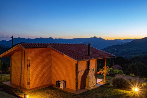 a small building with a view of the mountains at Chales Canto da Natureza in São Bento do Sapucaí