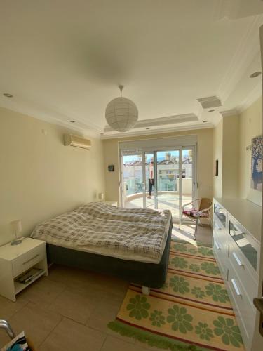 ein Schlafzimmer mit einem großen Bett und einem großen Fenster in der Unterkunft Cleopatra Uygun Apartment in Alanya