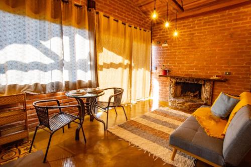 a living room with a couch and a table and a fireplace at Chales Canto da Natureza in São Bento do Sapucaí