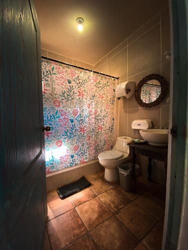 a bathroom with a toilet and a sink at Hotel Maya Jade in Monterrico