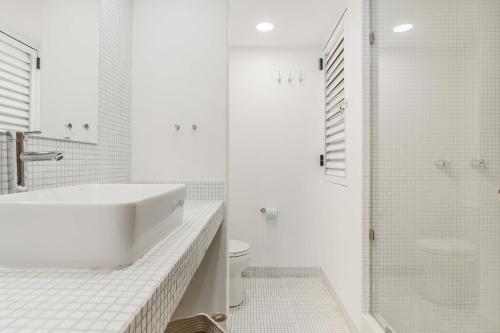 a white bathroom with a sink and a shower at BeachAccess HotelZone 3705 in Cancún