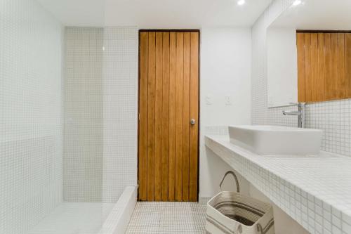 a bathroom with a sink and a wooden door at BeachAccess HotelZone 3705 in Cancún