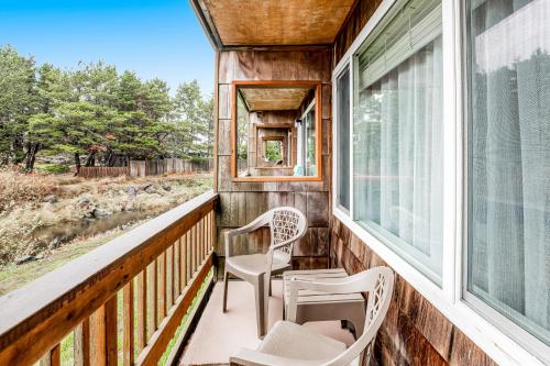 a porch with two chairs and a window at Sandy Landing in Neskowin