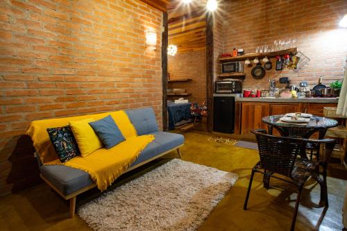 a living room with a couch and a brick wall at Chales Canto da Natureza in São Bento do Sapucaí