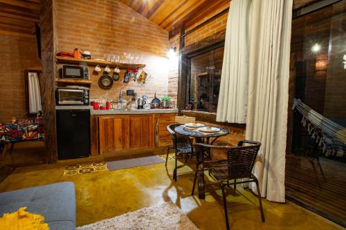 a kitchen with a table and chairs in a room at Chales Canto da Natureza in São Bento do Sapucaí