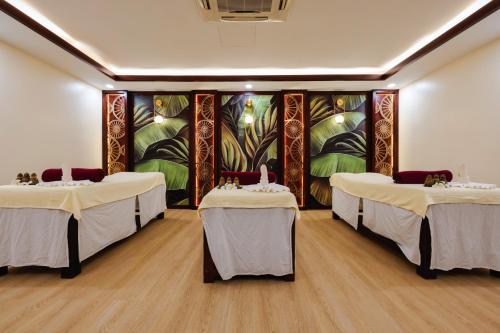 a room with three beds and a painting on the wall at Saem Siemreap Hotel in Siem Reap