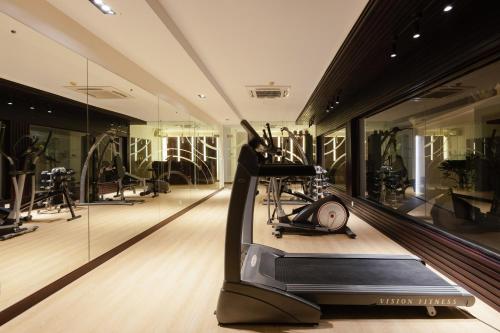 a fitness room with a treadmill and mirrors at Saem Siemreap Hotel in Siem Reap