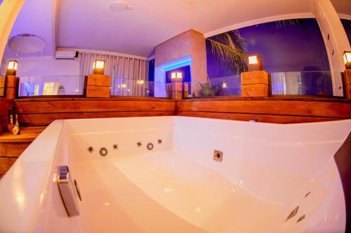 una gran bañera blanca en una habitación en Motel Itapuã I Fx Nova Camobi en Santa Maria