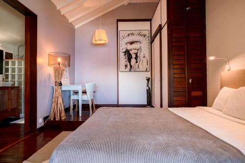 a bedroom with a bed and a table with a lamp at HAPPY COTTAGE WITH PRIVATE POOL in Saint Martin