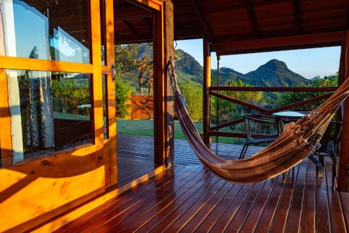 a hammock on the porch of a house at Chales Canto da Natureza in São Bento do Sapucaí
