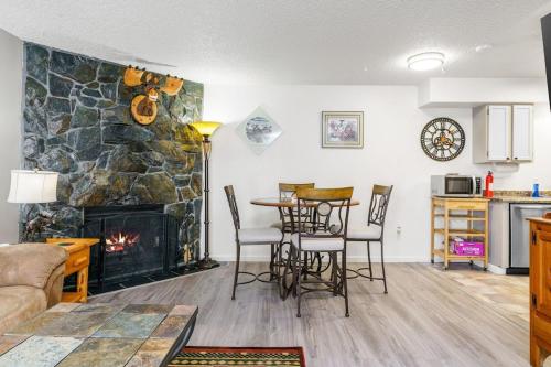 a living room with a fireplace and a table and chairs at The Moose Crossing in Anchorage