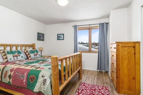 a bedroom with a wooden bed and a window at The Moose Crossing in Anchorage