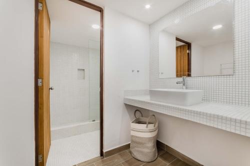 a white bathroom with a sink and a mirror at OceanView & Beach Access 3805 in Cancún