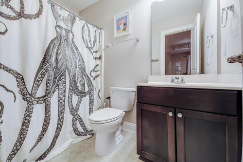 ein Badezimmer mit einem WC, einem Waschbecken und einem Duschvorhang in der Unterkunft Southern Charm Getaway in Charleston
